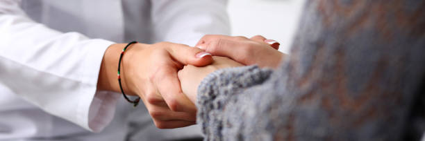 Two women with their hands clasped together